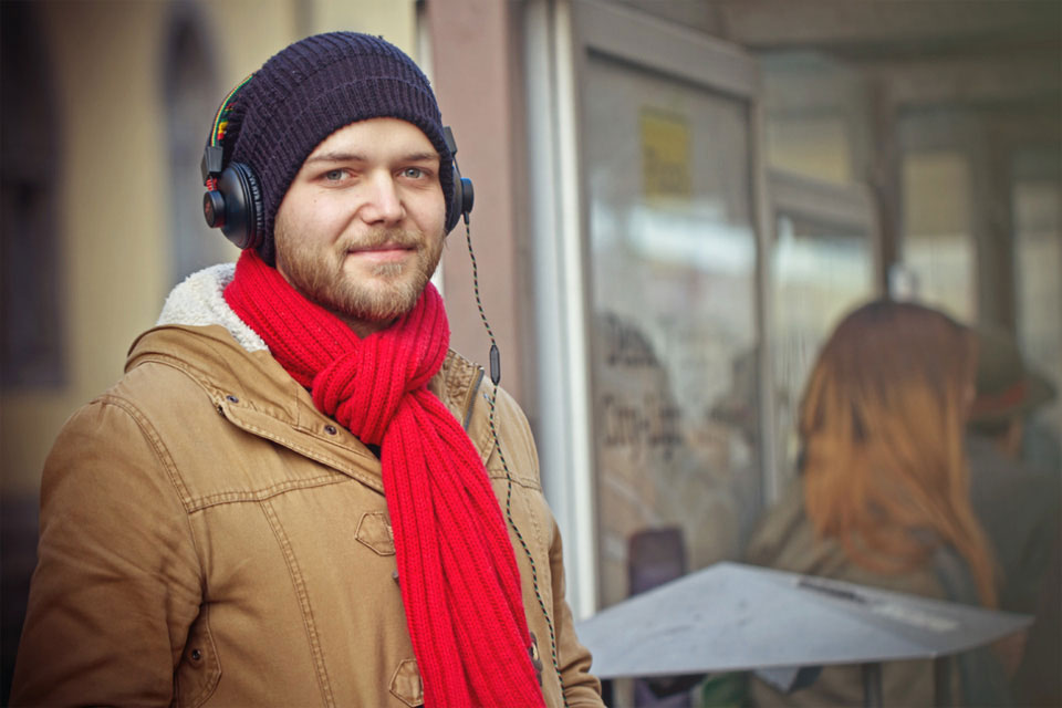 Mann mit Kopfhörern, roter Schal